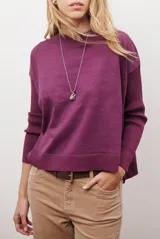 Buzo de punto color beige, con cuello redondo y manga larga.