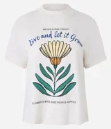 Remera color crema de algodón con cuello redondo y mangas cortas. Estampa frontal con una flor amarilla y texto en azul y verde.