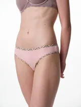 Bombacha tipo bikini de tiro medio confeccionada en algodón acanalado blanco, con bordes terminados en ribete con estampado animal print.