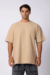 Remera de corte oversize color beige, con cuello redondo y detalle de costura en forma de V en el frente.