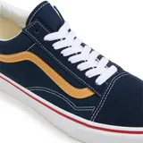Championes Vans modelo Old Skool, color azul marino con la icónica banda lateral en color mostaza. Presentan suela de goma blanca con una línea roja decorativa, cordones blancos y construcción en lona y gamuza.