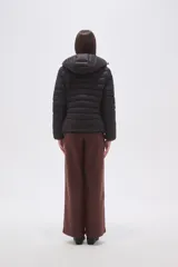 Campera puffer negra de nylon con diseño acolchado, cierre frontal y capucha integrada.