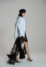 Falda larga negra de encaje con diseño transparente, tiro alto y aberturas que aportan movimiento.