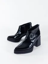 Bota corta negra de cuero charol, con cierre interno, plataforma delantera y taco cuadrado.