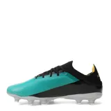 Championes de fútbol Umbro modelo Fly Hg, con diseño bicolor en negro y verde turquesa. Presentan cordones negros, interior amarillo y suela con tapones transparentes.