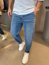 Jean de corte slouchy en color azul medio con lavado desgastado. Presenta un diseño de tiro medio, bolsillos laterales y traseros, y terminación en botamanga recta.