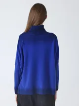 Suéter de tejido de punto con efecto degradado, pasando de gris oscuro a gris medio. Presenta cuello alto y mangas largas con puños acanalados.