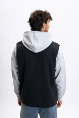 Chaleco de polar negro con cierre frontal completo, cuello alto y bolsillos laterales.
