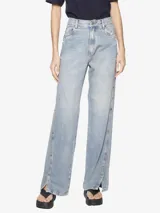 Pantalón jean celeste de corte recto, con cintura media, pretina con presillas, tag de la marca en la parte posterior, aplicación de tachas laterales, recortes delanteros y traseros, largo extendido y abertura en la botamanga.