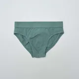 Pack de tres slips de algodón en color verde oscuro, verde y gris claro, con cintura elástica.