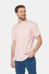 Camisa lisa de manga corta color crema, confeccionada en 100% algodón, con cuello abotonado y un bolsillo en el pecho.