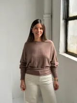 Sweater de punto color marrón, con cuello redondo, mangas largas con puños ajustados y diseño con textura acanalada vertical en el frente.