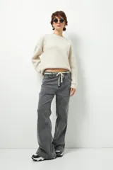 Pantalón de jean negro de corte ancho y tiro alto, con cordón ajustable en la cintura.