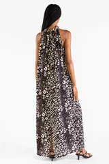 Vestido largo con cuello halter y estampado animal print combinando patrones de leopardo y cebra en tonos negro y crudo. Presenta diseño sin mangas y caída fluida.