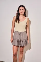 Minifalda con estampado de cuadros vichy en tonos marrón y blanco, con cintura elástica fruncida, cordón ajustable y volado en el ruedo.