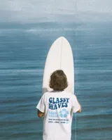 Remerón blanco de algodón con estampado en el frente que dice "Glassy Waves", "Good Vibes", una flor de hibisco y las fechas "1971. 1982. 1999" en color celeste y azul.