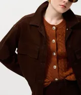 Campera de sarga acanalada color marrón, con cuello camisero estructurado, cierre frontal con botones, mangas largas con puños y bolsillos delanteros con solapa.