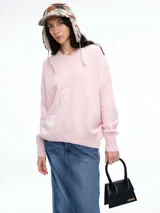 Sweater de tejido de punto en color rosa claro con motas de colores, de corte holgado, cuello redondo y mangas largas con hombros caídos.