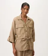 Campera tipo parka de la marca Marfinno, confeccionada en mezcla de algodón, viscosa y lino en color beige. Presenta cuello camisero, cierre frontal con botones, bolsillos con solapa en el pecho y cintura ajustable con cordón y lazo. Las mangas son largas con puños abotonados.