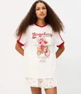 Remera blanca de algodón con mangas cortas, cuello redondo y ribetes rojos en contraste. Presenta estampa frontal de Strawberry Shortcake y lettering con texto en inglés y rojo.