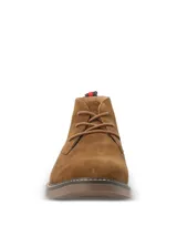 Botas tipo chukka Hush Puppies modelo New Safari, confeccionadas en descarne color marrón tostado. Presentan cordones al tono, costuras reforzadas en la suela y detalle de etiqueta con franjas en el talón.