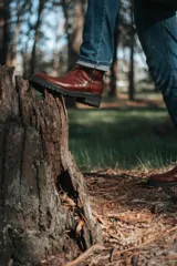 Bota corta color marrón de cuero con cierre lateral y suela de goma.