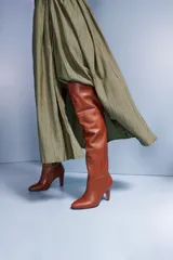 Bota de cuero negra con caña alta, taco fino y cierre lateral.