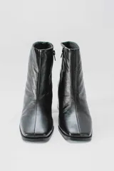 Botas plateadas de cuero con caña media, cierre lateral con cremallera, punta cuadrada y tacón geométrico de madera.