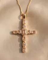 Collar de bronce con baño de oro y dije de cruz decorado con piedras naturales rosadas y circonias.