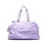 Bolso deportivo de gran capacidad en color lila, confeccionado en material textil con acabado arrugado. Cuenta con doble asa superior, correa ajustable y desmontable, y compartimento principal con cierre doble. Incluye correas en la base para sujetar accesorios y una bolsa interior desmontable.