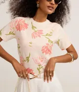Blusa slim de cuello redondo y manga corta, confeccionada en algodón con un delicado estampado floral.