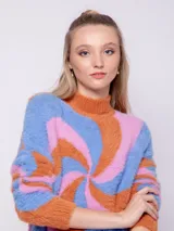 Polera de tejido de punto con diseño de jacquard en espiral en tonos celeste, rosa y naranja. Es de textura peludita, manga larga y cuello alto.
