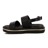 Sandalia de plataforma color negro, con dos tiras anchas sobre el empeine y una tira ajustable con hebilla dorada en el tobillo. La plataforma tiene un detalle de línea dorada.