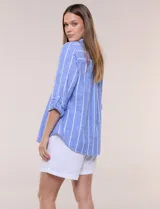 Camisa de lino de la marca Dash, color beige con rayas verticales blancas. Cuenta con cuello camisero, cierre frontal con botones, un bolsillo aplicado en el pecho y mangas largas con sistema de ajuste para arremangar.