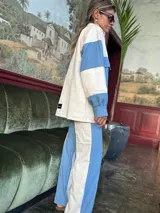 Pantalón de corte recto con diseño bicolor en bloques verticales, combinando paneles de jean azul y gabardina color crema.