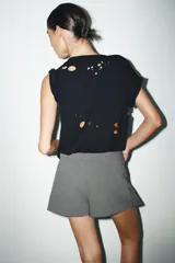 Falda pantalón de tiro medio en color gris, con diseño de tablas y cinturón integrado con hebilla metálica lateral.