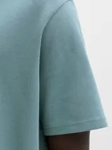 Remera de manga corta color verde con cuello redondo y calce relajado. Presenta un pequeño bordado o estampa en el pecho.