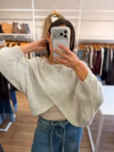 Capa tejida de punto en color verde oliva, con diseño cruzado en el frente y mangas tipo murciélago de calce holgado.