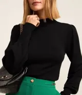 Suéter negro de punto con cuello alto, mangas largas abullonadas y puños largos.