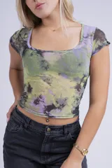 Remera corta de mesh con estampado abstracto en tonos violeta y rosa, de mangas cortas y cuello cuadrado.