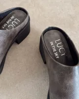 Zueco de cuero negro con punta redondeada y taco cuadrado de 4.5 cm. Diseño tipo mule con plantilla acolchada y marca Lucy in the Sky.