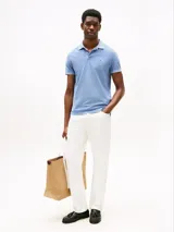 Chomba celeste de algodón con cuello clásico, tapeta de tres botones y logo de Tommy Hilfiger bordado en el pecho.