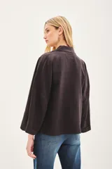 Saco de lino y liocel de corte amplio, con solapa, bolsillos falsos y mangas de largo regular. Incluye un pin decorativo en la solapa.