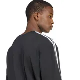 Remera Adidas de corte holgado, color negro, con cuello redondo y mangas cortas. Presenta las icónicas tres tiras blancas en los hombros y el logo del trébol bordado en el pecho.