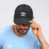 Gorro negro de algodón con visera curva y logo de Umbro bordado en blanco en el frente.