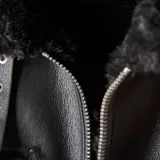 Campera de cuero sintético negro con interior y detalles de piel sintética al tono. Presenta cierre frontal metálico, bolsillos frontales con solapa y diseño de corte recto.