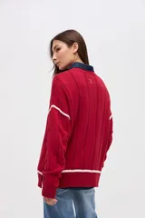 Buzo de punto tejido en algodón, con diseño de ochos y detalles en color blanco en sisas y ruedo. Presenta cuello redondo y calce holgado.