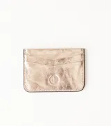 Tarjetero de cuero color dorado con tres ranuras para tarjetas y logo en relieve en la parte inferior.