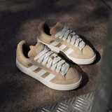 Championes Adidas modelo Grand Court Alpha, color arena con las icónicas tres tiras laterales en blanco. Presentan una combinación de gamuza y malla en la parte superior, con suela de goma blanca y cordones al tono.