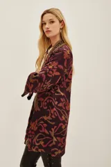 Kimono de viscosa con estampado ikat en tonos bordó y rosado, con bordes decorados con detalles geométricos y mangas tres cuartos.